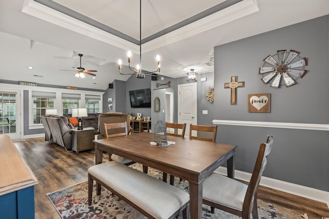 dining area featuring lofted ceiling, ceiling fan with notable chandelier, crown molding, and dark hardwood / wood-style flooring