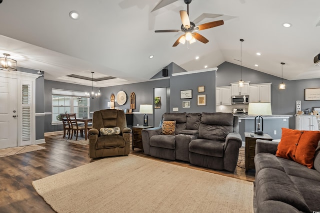 living room featuring ceiling fan with notable chandelier, hardwood / wood-style flooring, and lofted ceiling