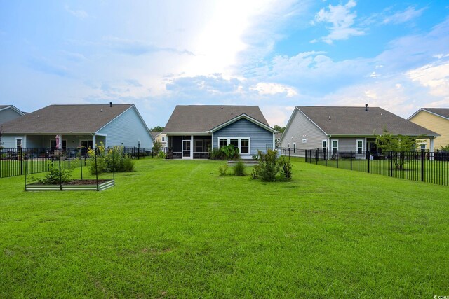 back of property with a lawn and a sunroom