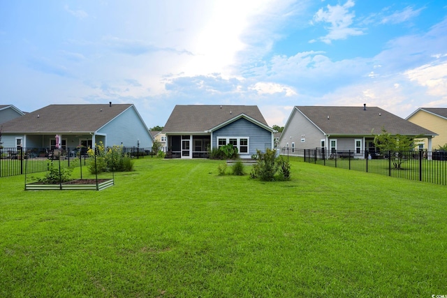 rear view of property with a sunroom, a fenced backyard, and a yard