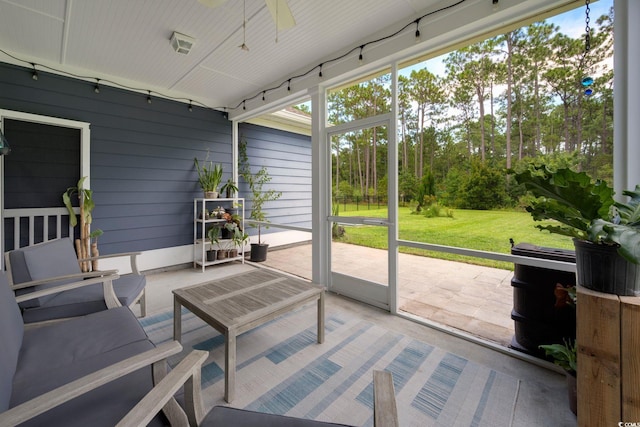 sunroom / solarium featuring a ceiling fan