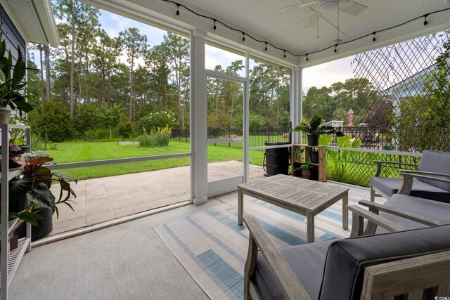 sunroom / solarium featuring ceiling fan