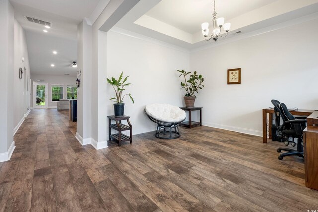 office area with an inviting chandelier, dark wood-type flooring, and a raised ceiling