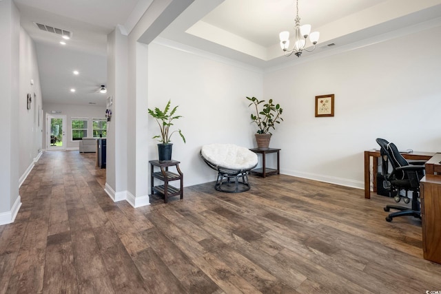 office area with baseboards, visible vents, wood finished floors, an inviting chandelier, and a tray ceiling