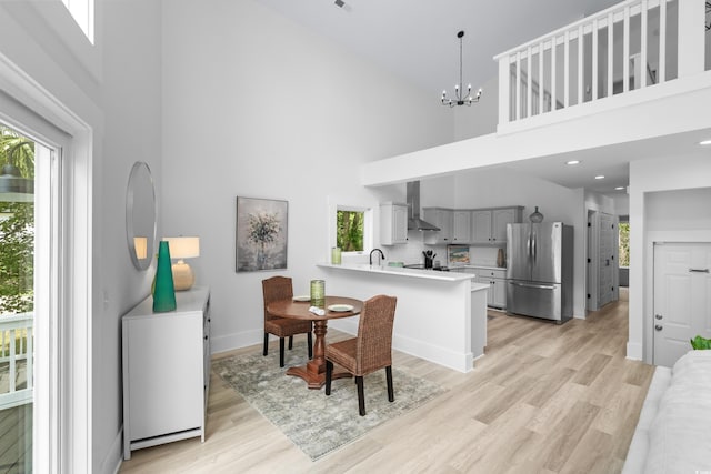 dining area with light hardwood / wood-style flooring and a high ceiling