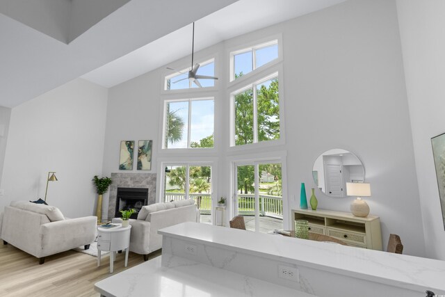 living room featuring light wood-type flooring, a high ceiling, and a chandelier