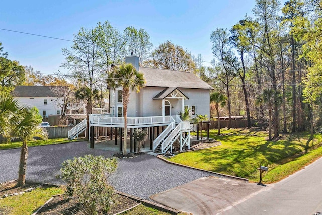 view of front of home with a wooden deck and a front lawn