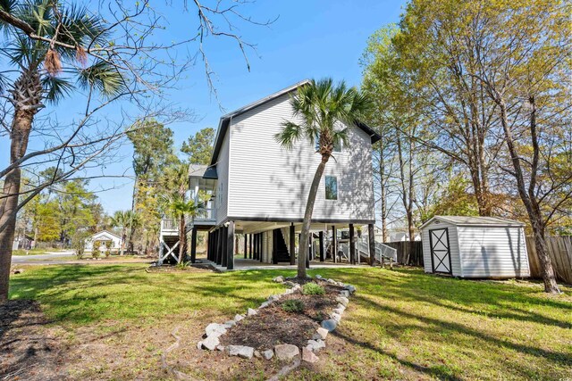 back of house featuring a storage shed and a yard