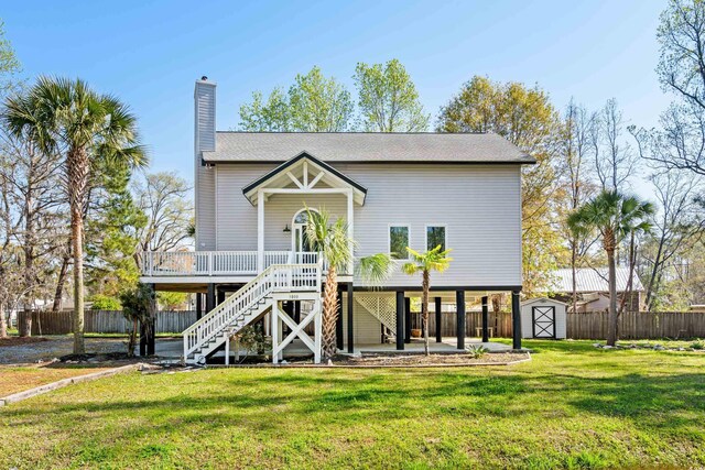 back of house with a lawn and a storage unit