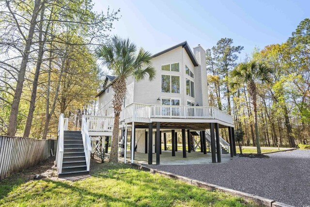 coastal inspired home with a front yard and a deck