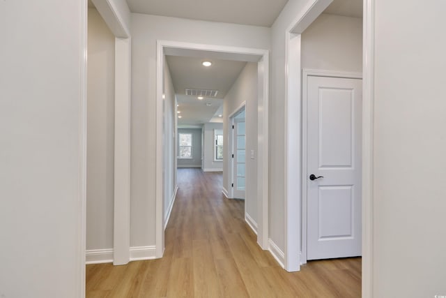 hallway with light hardwood / wood-style floors