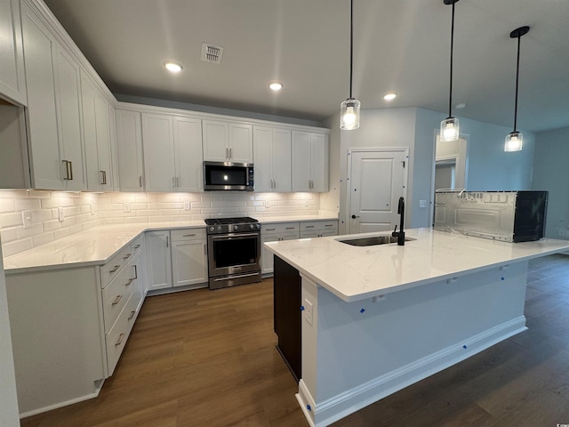 kitchen with appliances with stainless steel finishes, decorative light fixtures, sink, and white cabinets