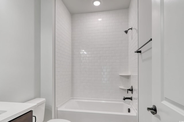 full bathroom featuring vanity, tiled shower / bath combo, and toilet