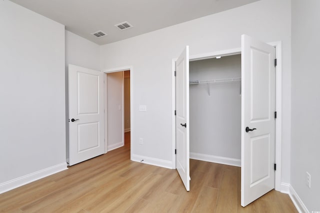 unfurnished bedroom featuring light hardwood / wood-style floors and a closet