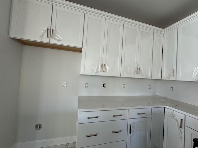 kitchen with light stone countertops and white cabinets