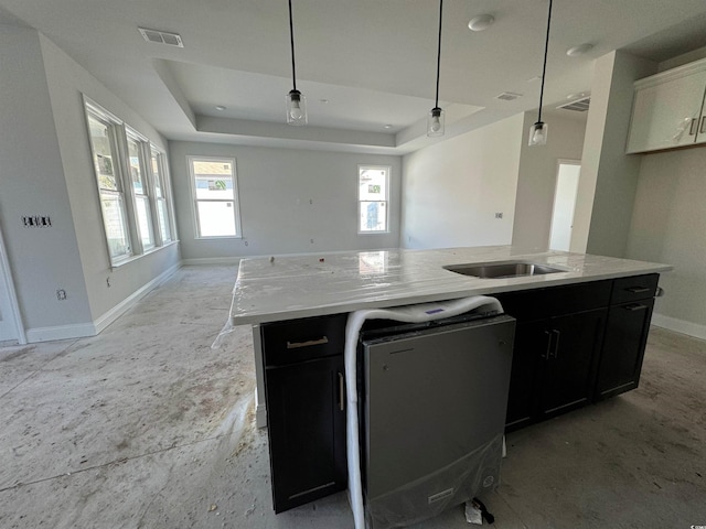 kitchen featuring dishwashing machine, sink, a kitchen island with sink, decorative light fixtures, and a raised ceiling