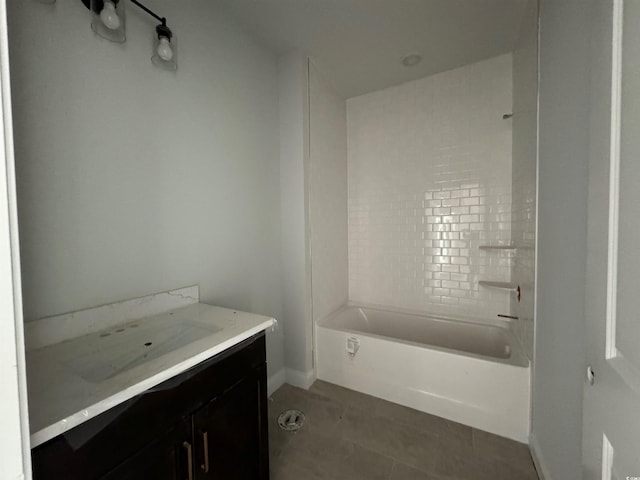 bathroom featuring tile patterned flooring, vanity, and tiled shower / bath