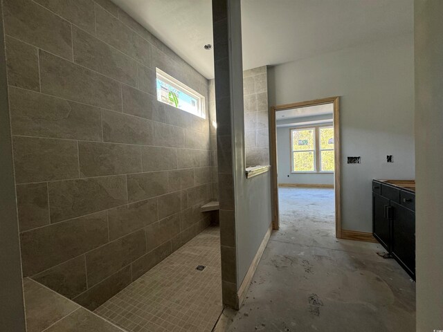 bathroom featuring vanity, tiled shower, and a wealth of natural light