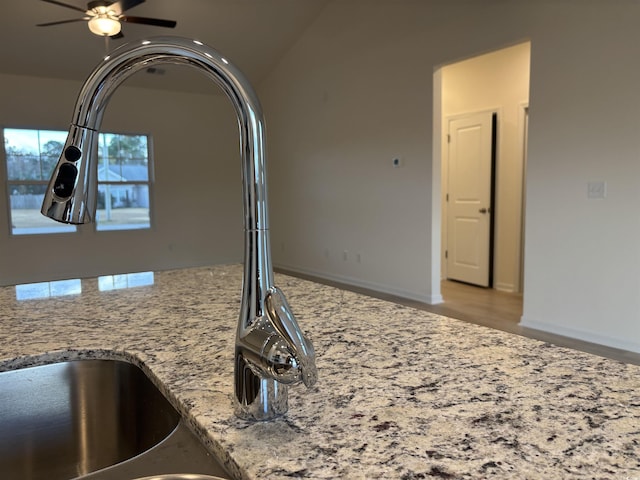 details featuring hardwood / wood-style flooring, ceiling fan, light stone countertops, and sink