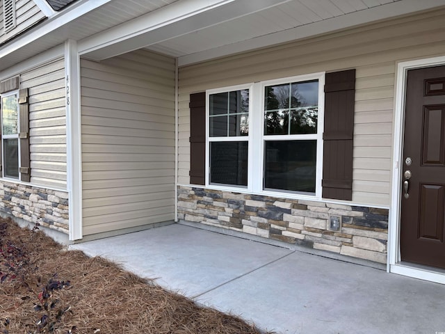 view of exterior entry with a patio area