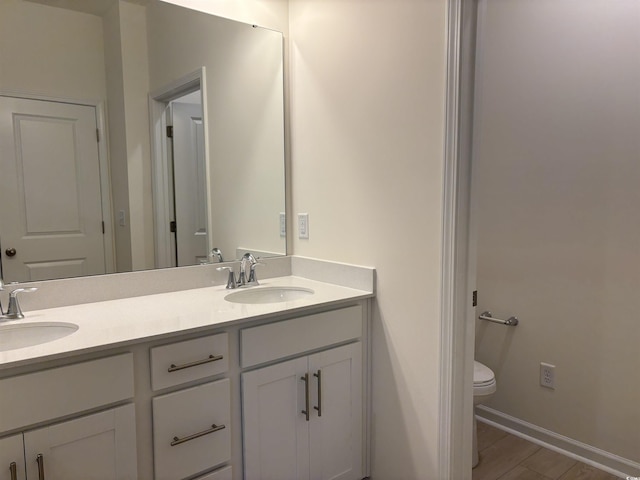 bathroom featuring hardwood / wood-style floors, vanity, and toilet