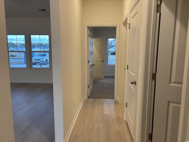 hallway with light hardwood / wood-style floors