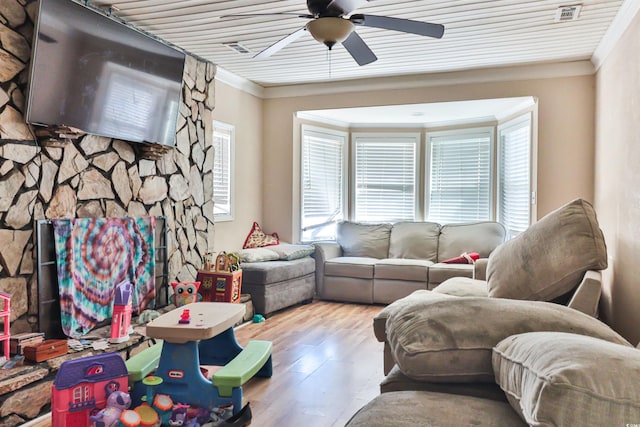 living room with wood ceiling, a fireplace, hardwood / wood-style floors, crown molding, and ceiling fan