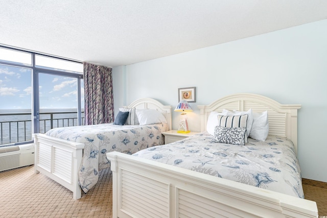 carpeted bedroom featuring a textured ceiling, a water view, and access to exterior