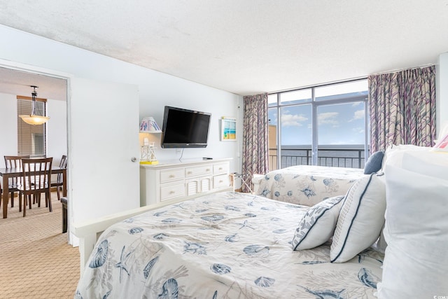 bedroom featuring floor to ceiling windows, a textured ceiling, light colored carpet, and access to outside