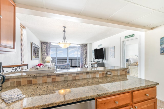 kitchen with hanging light fixtures and light stone counters