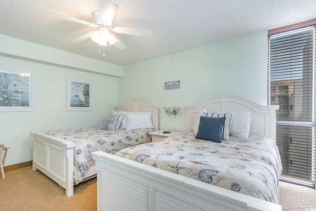 bedroom featuring ceiling fan, a textured ceiling, and light carpet