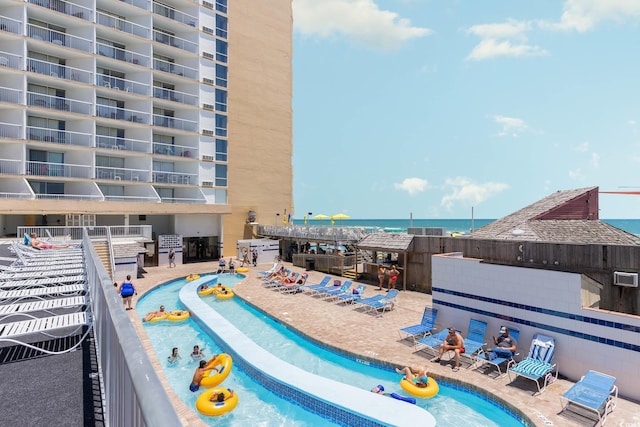 view of swimming pool with a water view and a patio area