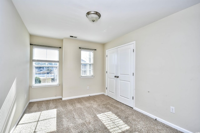 spare room featuring light carpet and plenty of natural light