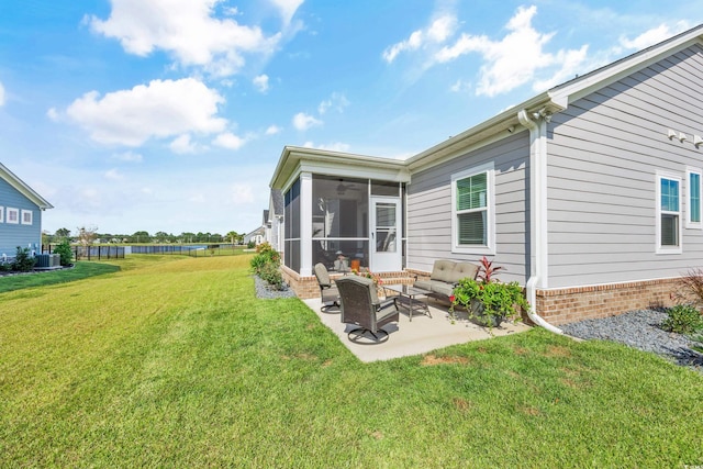 rear view of house featuring cooling unit, a lawn, a patio, and a sunroom