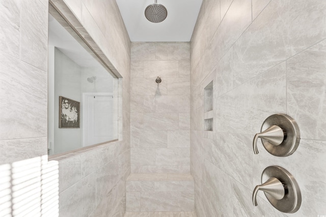 bathroom featuring tile walls and a tile shower