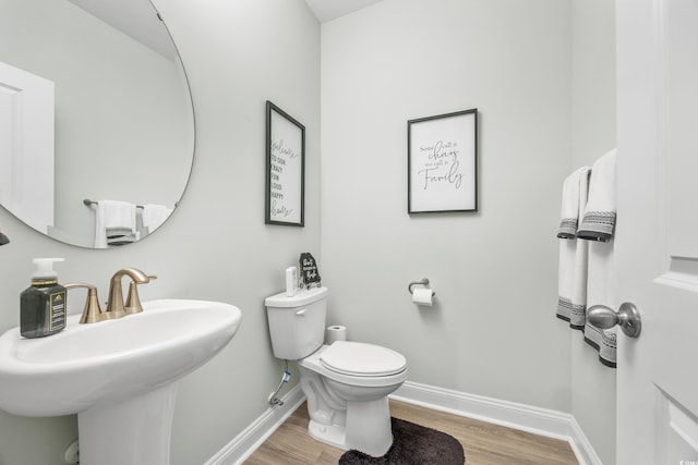 bathroom with toilet, sink, and hardwood / wood-style floors