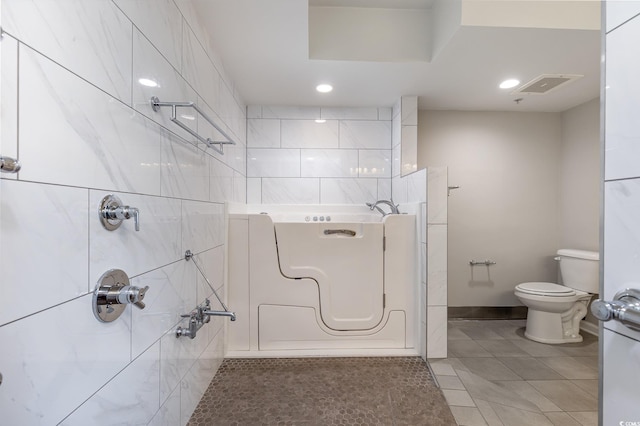 bathroom featuring toilet, shower with separate bathtub, and tile patterned flooring