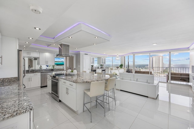 kitchen with appliances with stainless steel finishes, light stone counters, and white cabinets