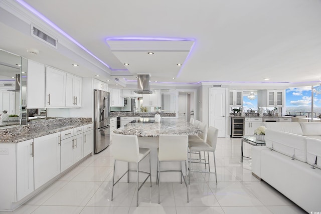 kitchen with white cabinets, stainless steel fridge with ice dispenser, and stone counters