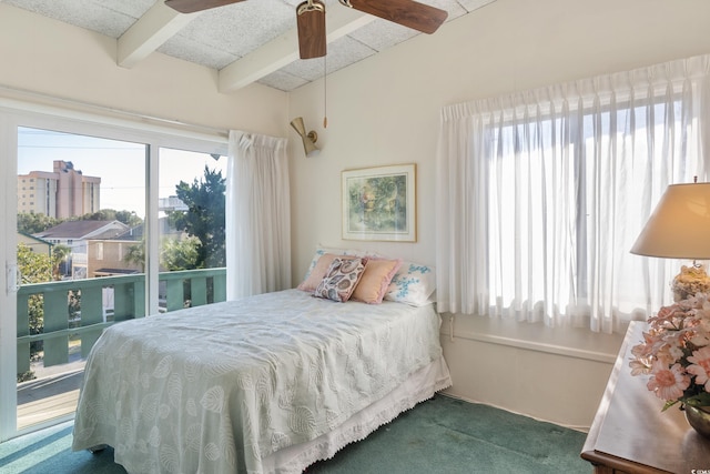 carpeted bedroom featuring beamed ceiling and ceiling fan