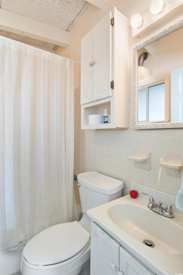 1000 Strand Ave, North Myrtle Beach, SC 29582 - bathroom featuring tile walls, toilet, vanity, decorative backsplash, and shower / bath combo with shower curtain