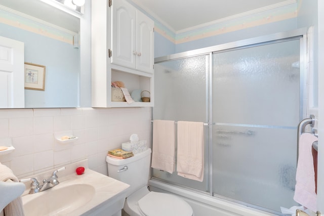 full bathroom with tile walls, shower / bath combination with glass door, ornamental molding, vanity, and toilet