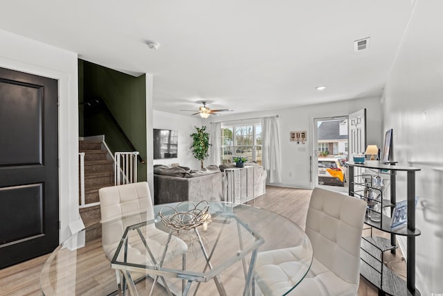 dining space with light wood-type flooring and ceiling fan