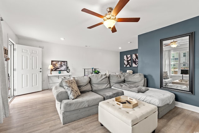 living room with light hardwood / wood-style floors and ceiling fan