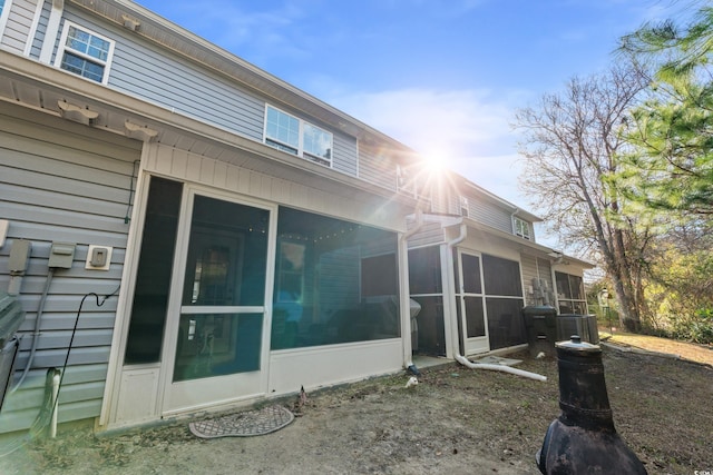 rear view of house featuring a sunroom