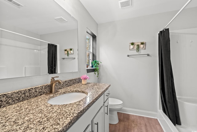 full bathroom featuring vanity, toilet, wood-type flooring, and shower / tub combo