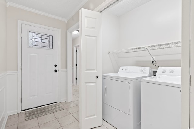 washroom featuring crown molding, a textured ceiling, light tile patterned floors, and separate washer and dryer