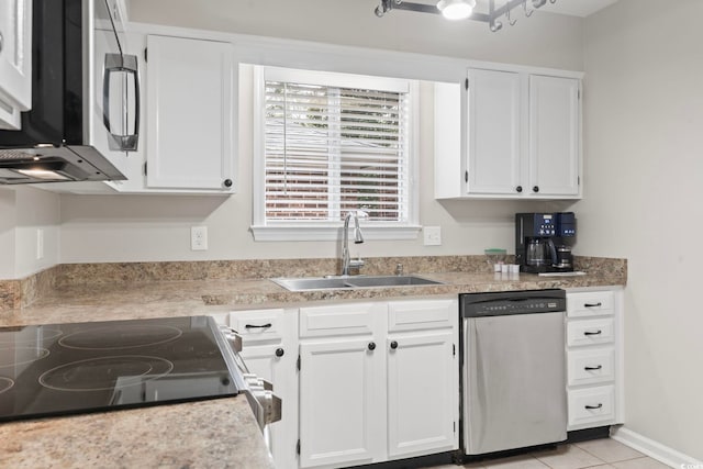 kitchen with stainless steel appliances, sink, light tile patterned flooring, and white cabinets