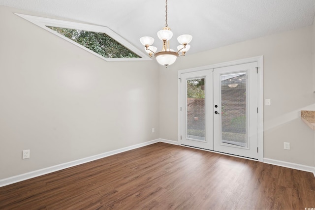 interior space with french doors, dark hardwood / wood-style floors, vaulted ceiling, a chandelier, and a textured ceiling