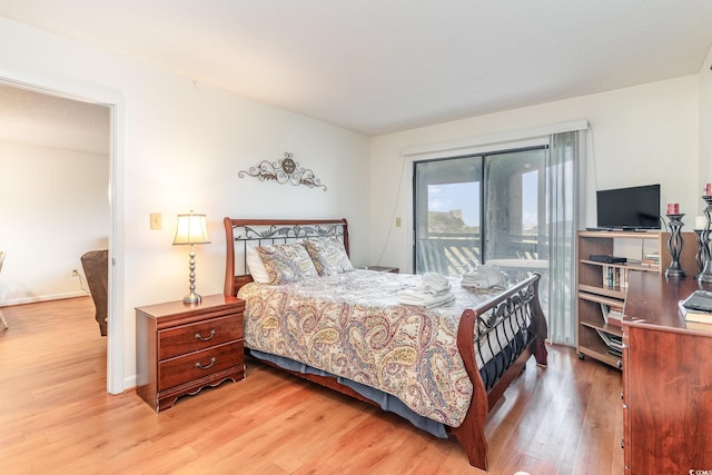 bedroom with access to exterior and light hardwood / wood-style flooring